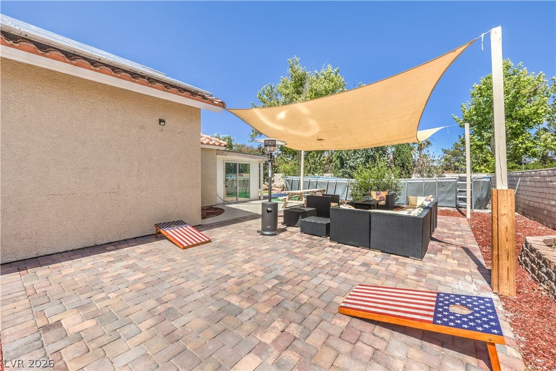 A spacious paved patio area provides an inviting outdoor setting adjacent to the home.