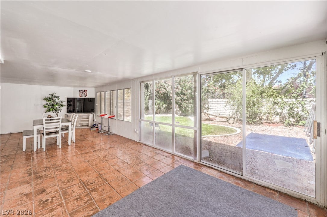 Tiled flooring and expansive glass doors define this versatile sunroom looking out to the yard.