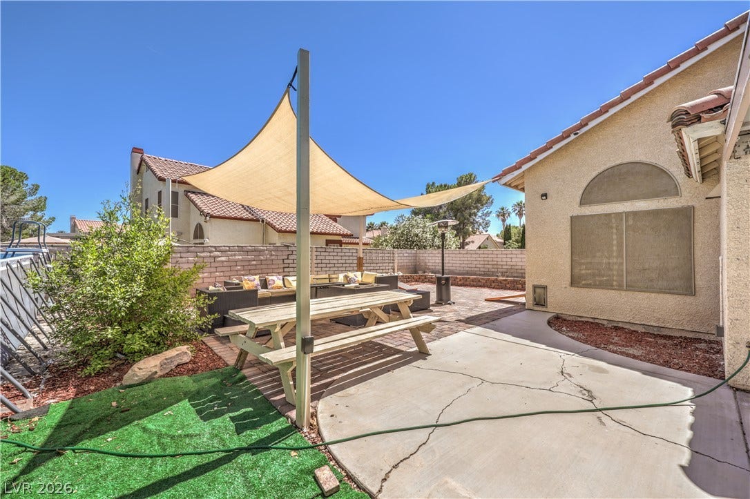 Sun shade sails canopy over a paved patio area ideal for outdoor dining.