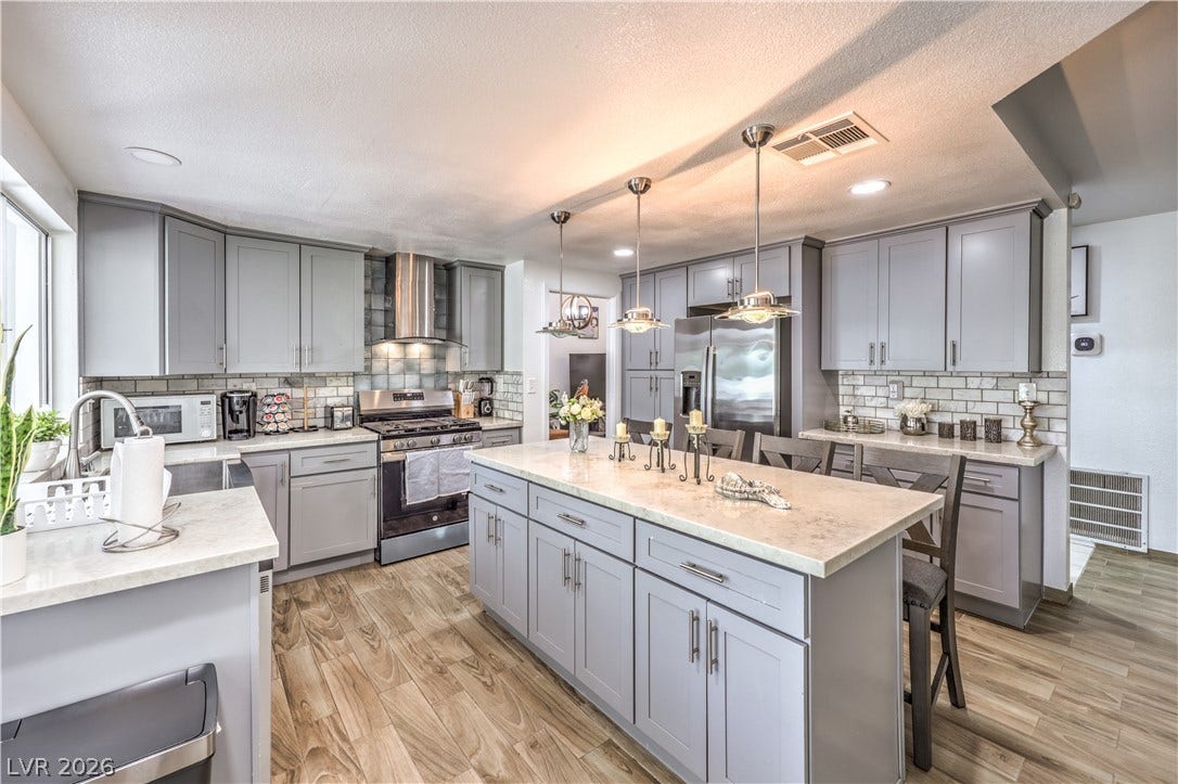 Modern cabinetry and stone countertops anchor this beautifully updated kitchen with wood-look flooring.