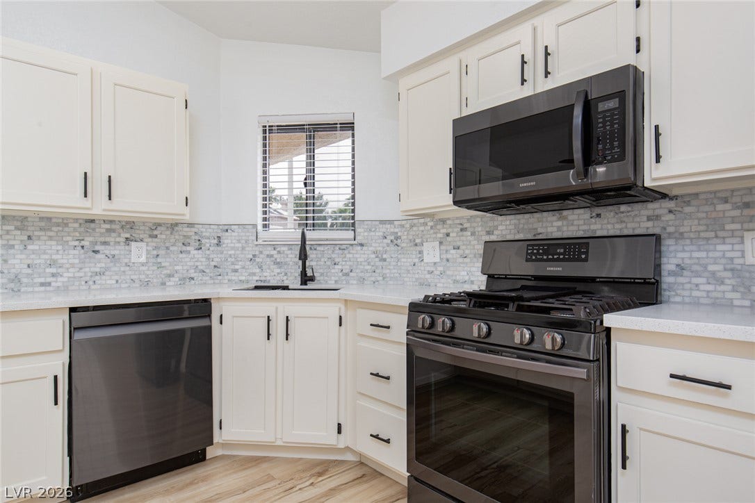 352 Lander Drive, Henderson, NV 89074 Timeless cabinetry and textured tile backsplash define this updated kitchen workspace.