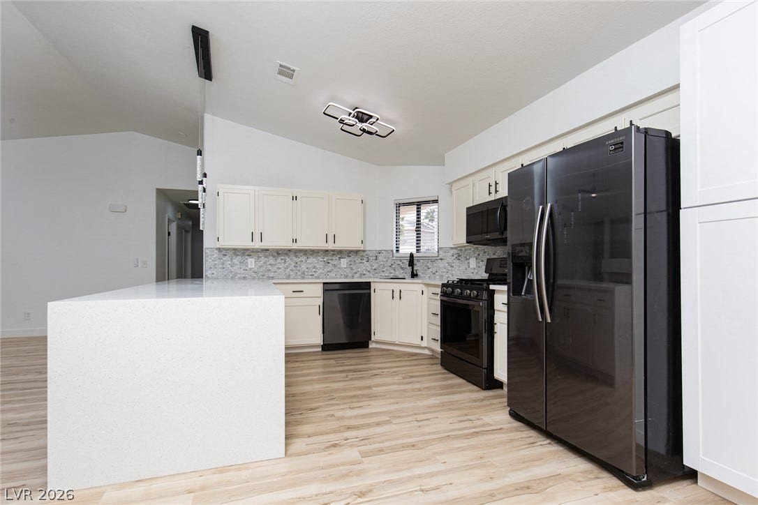 352 Lander Drive, Henderson, NV 89074 An open kitchen displays durable wood-look flooring alongside clean countertops and modern cabinetry.