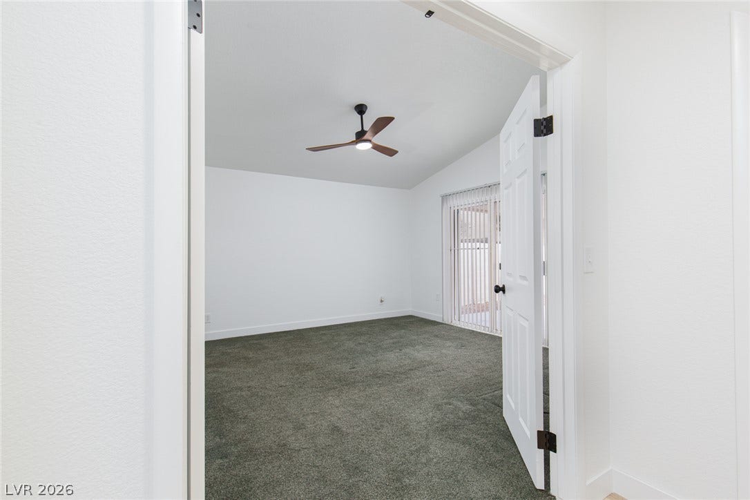 352 Lander Drive, Henderson, NV 89074 A vaulted ceiling and plush carpeting define this airy bedroom with sliding door access.