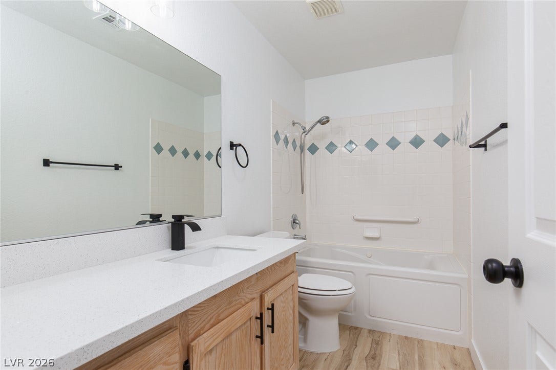352 Lander Drive, Henderson, NV 89074 Tiled bath accents and light wood cabinetry define this functional secondary bathroom.