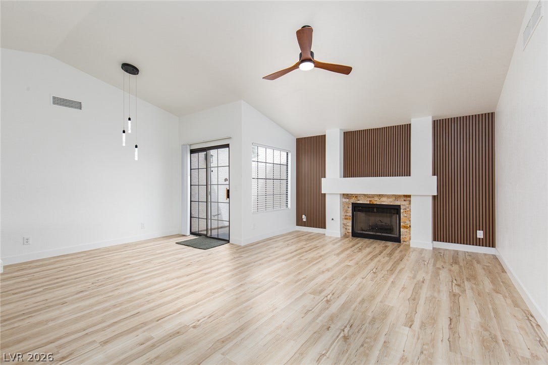352 Lander Drive, Henderson, NV 89074 A stone fireplace anchors this living space detailed with wood flooring and vaulted ceilings.