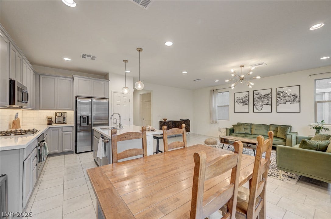 4114 Billowing Breeze Avenue, North Las Vegas, NV 89081 An open floor plan seamlessly connects the kitchen, dining area, and living space under recessed lighting.