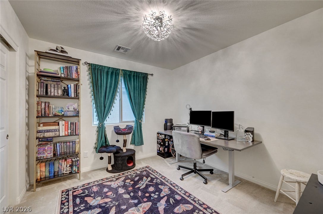 4114 Billowing Breeze Avenue, North Las Vegas, NV 89081 A versatile home office area features soft carpet and a centrally positioned window.