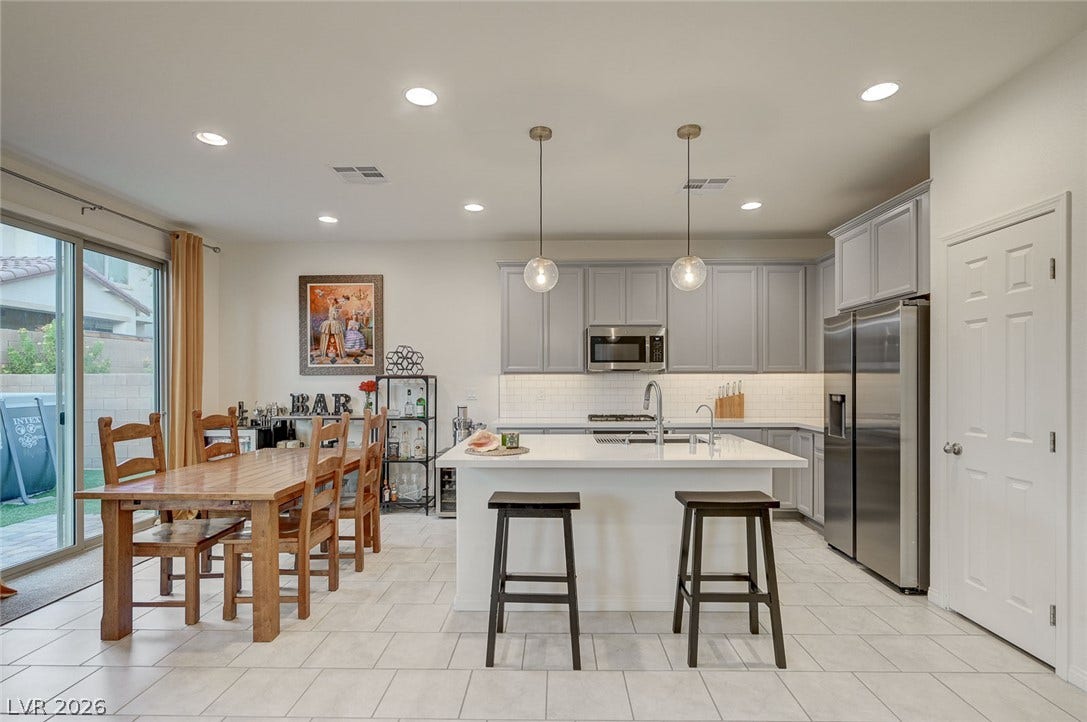 4114 Billowing Breeze Avenue, North Las Vegas, NV 89081 An open kitchen features a central island, recessed lighting, and tile flooring.