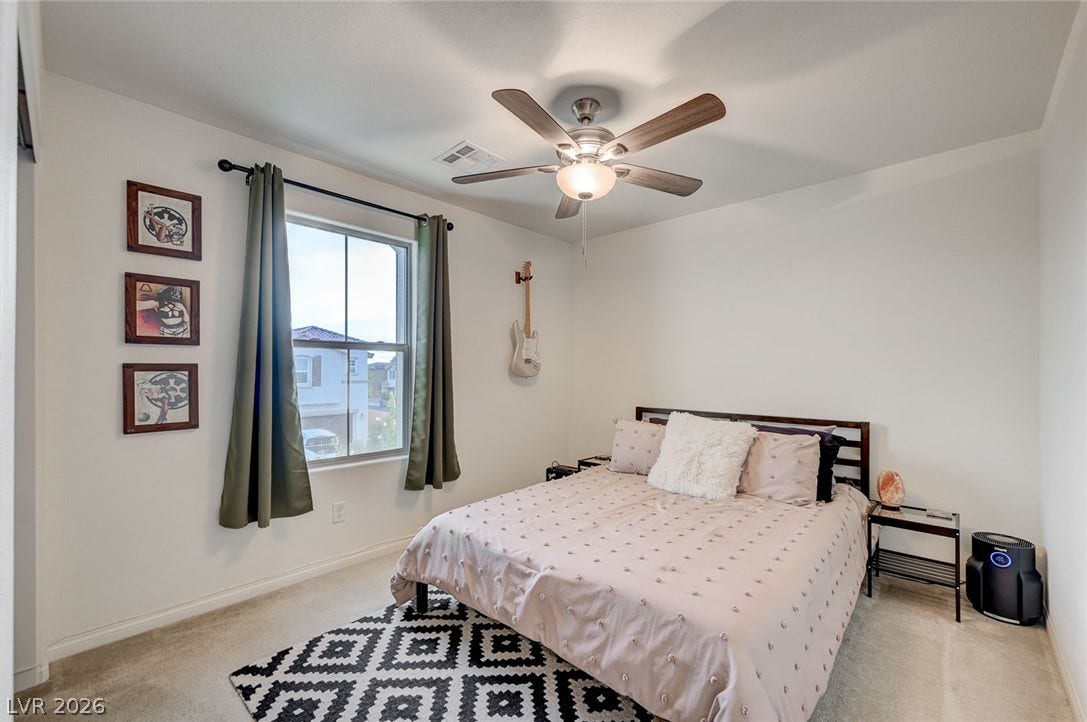 4114 Billowing Breeze Avenue, North Las Vegas, NV 89081 A tall window draws natural light into this carpeted bedroom.