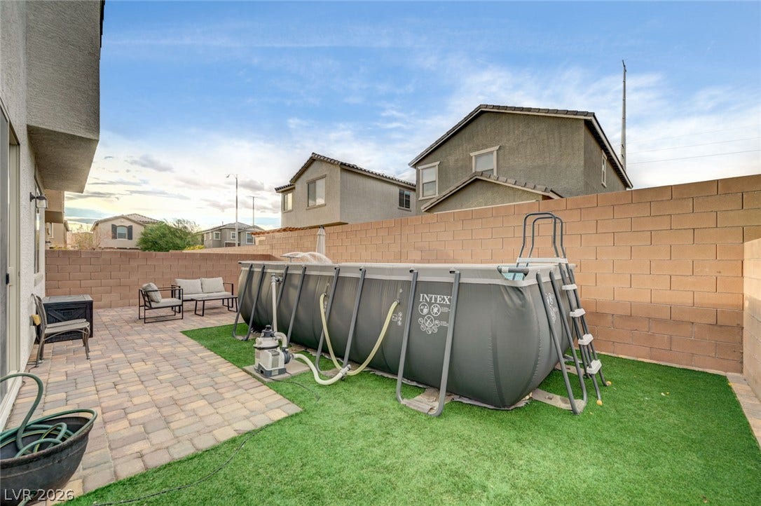 4114 Billowing Breeze Avenue, North Las Vegas, NV 89081 A spacious backyard features a paved patio area alongside a neat synthetic lawn.