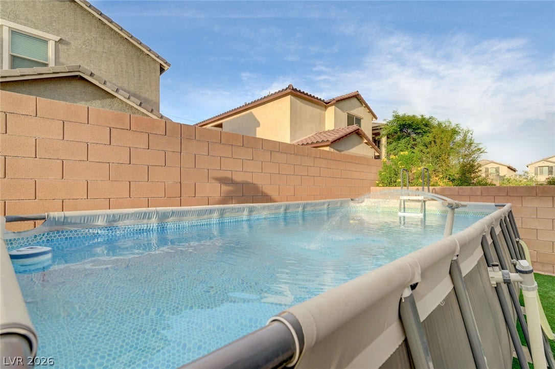 4114 Billowing Breeze Avenue, North Las Vegas, NV 89081 An above-ground pool sits within a private backyard enclosed by tall block walls.