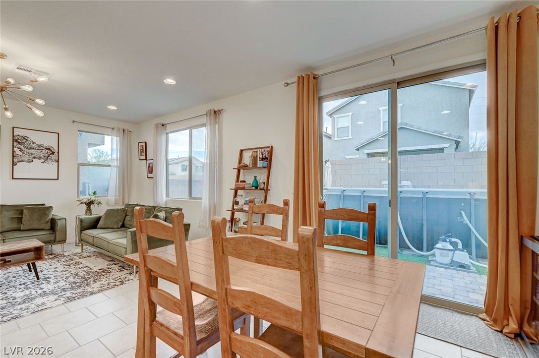 4114 Billowing Breeze Avenue, North Las Vegas, NV 89081 Sliding glass doors open from the tiled dining area to the backyard space.