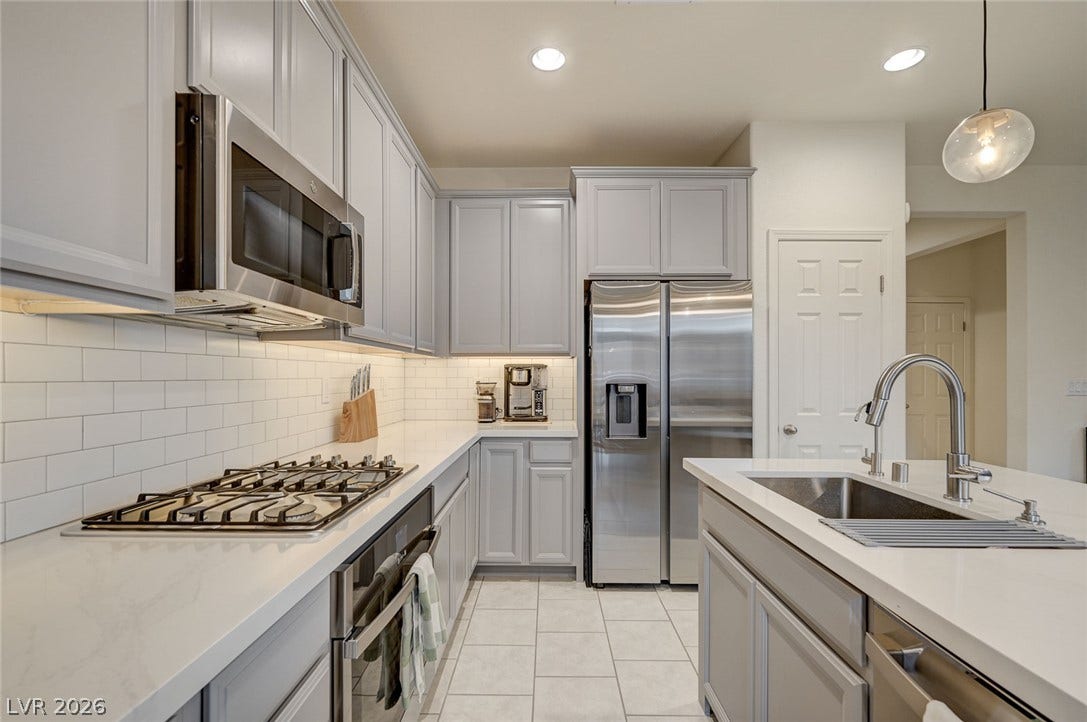4114 Billowing Breeze Avenue, North Las Vegas, NV 89081 Sleek stone countertops and timeless subway tile backsplash highlight this contemporary workspace.