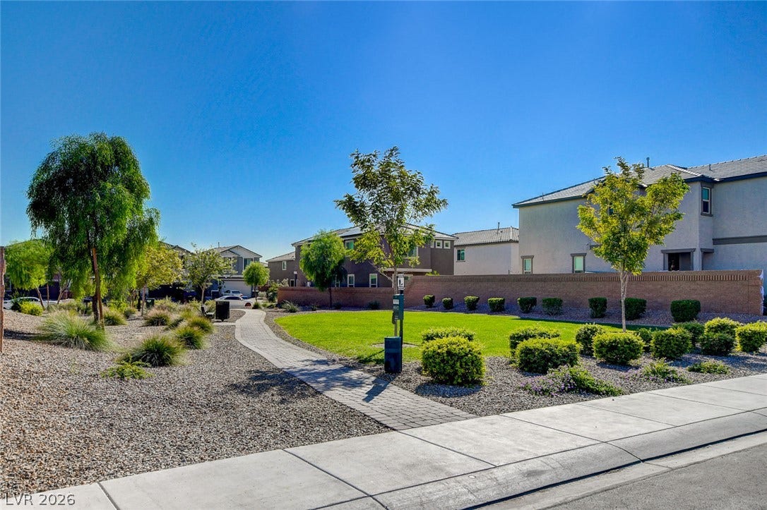 4114 Billowing Breeze Avenue, North Las Vegas, NV 89081 A paved path winds through manicured landscaping bordering a lush community park.
