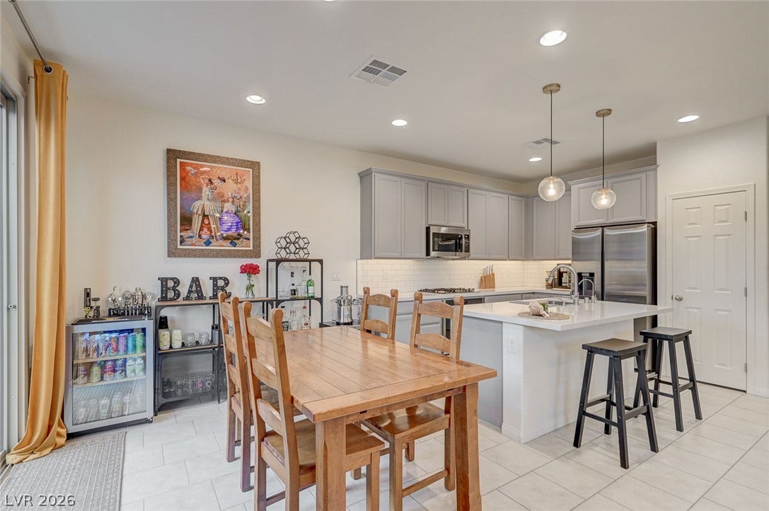 4114 Billowing Breeze Avenue, North Las Vegas, NV 89081 Gleaming tile floors anchor an airy kitchen equipped with modern shaker cabinets and recessed lighting.