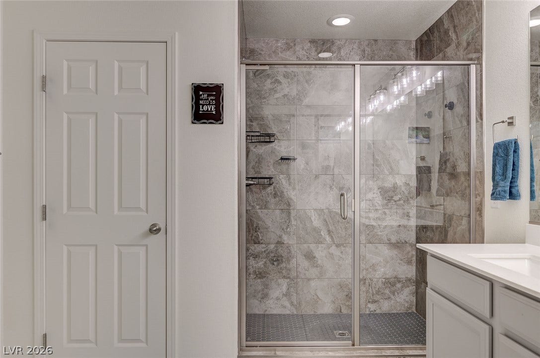 4114 Billowing Breeze Avenue, North Las Vegas, NV 89081 Elegant tilework and a glass door elevate this walk-in shower design.