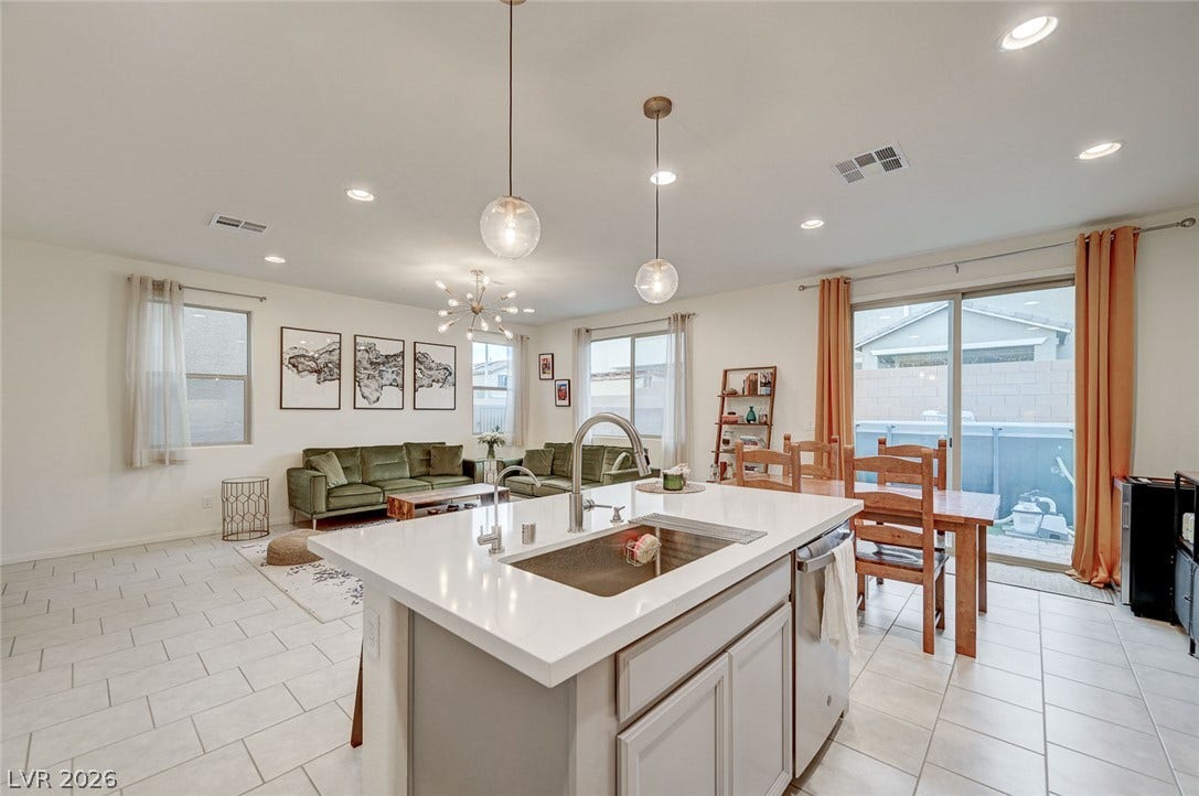 4114 Billowing Breeze Avenue, North Las Vegas, NV 89081 An open floorplan seamlessly connects the modern kitchen island to the dining and living spaces.