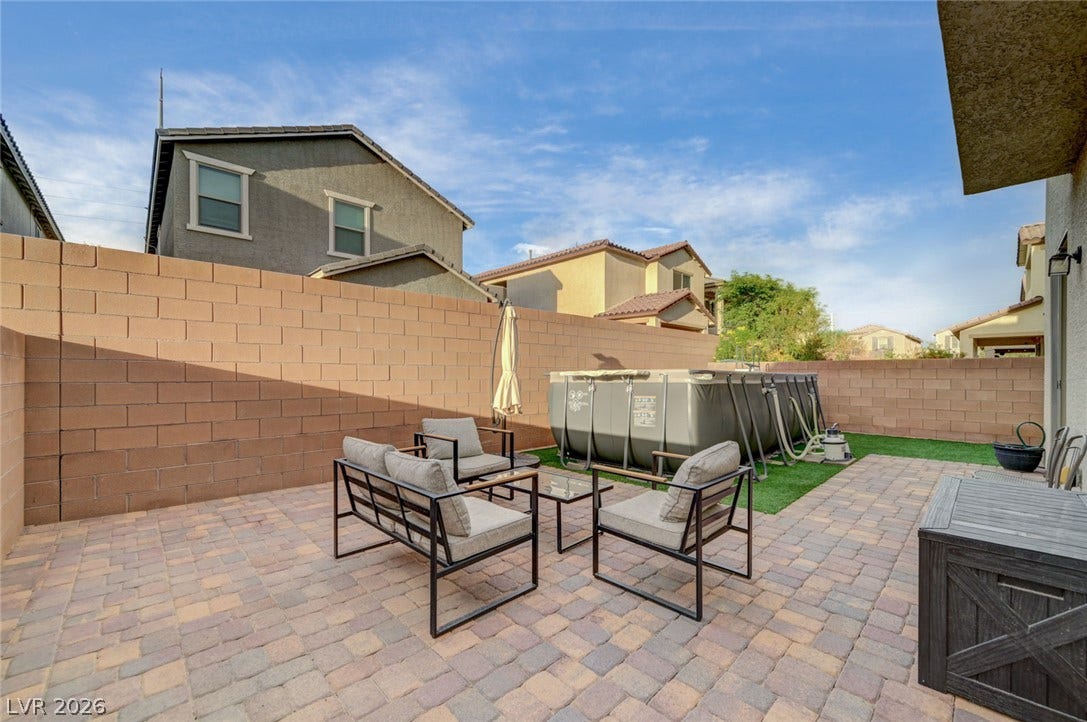 4114 Billowing Breeze Avenue, North Las Vegas, NV 89081 A spacious brick-walled backyard features durable paver flooring and room for outdoor activities.