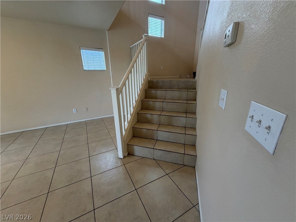 6420 W Casamar Street, North Las Vegas, NV 89086 Tiled flooring and neutral walls define this inviting entryway staircase.