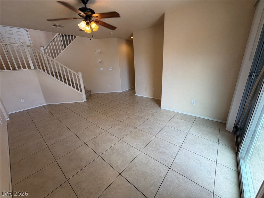 6420 W Casamar Street, North Las Vegas, NV 89086 Tiled flooring and a classic staircase anchor this versatile open living space.