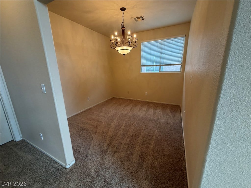 6420 W Casamar Street, North Las Vegas, NV 89086 An elegant chandelier illuminates this versatile room detailed with plush carpeting.
