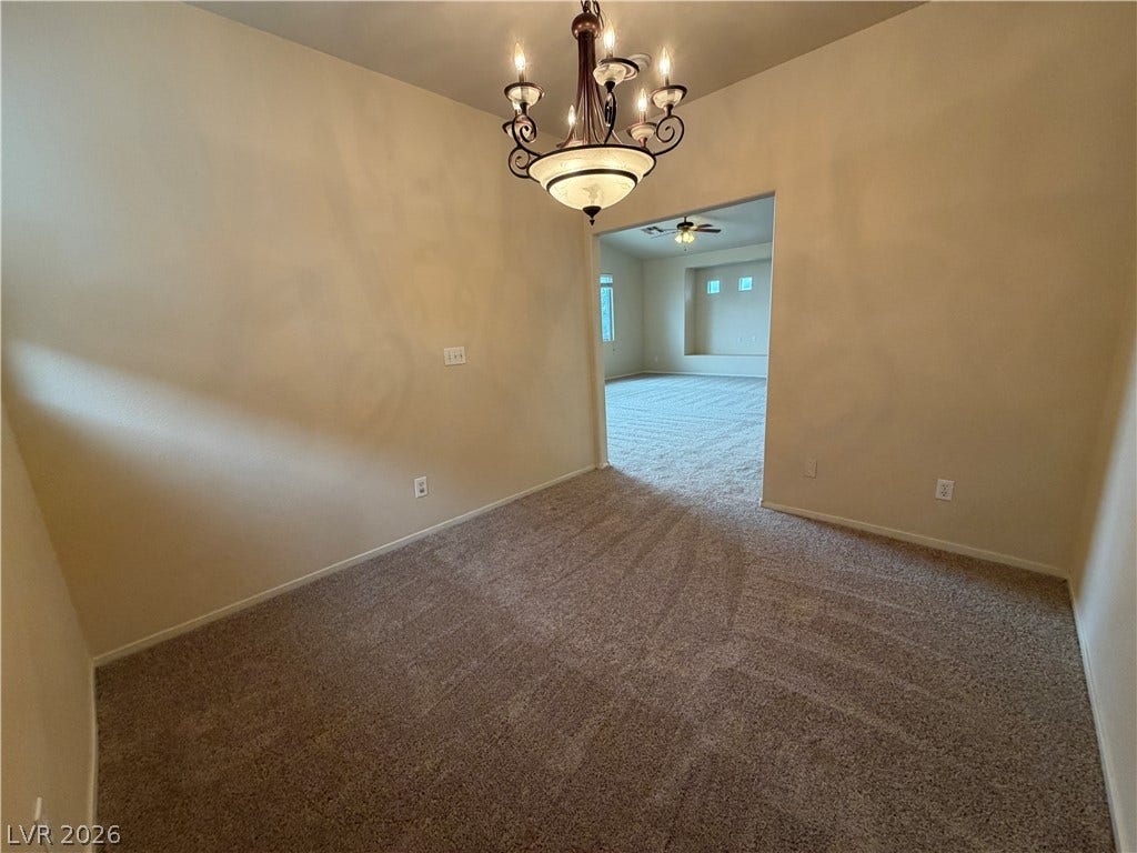 6420 W Casamar Street, North Las Vegas, NV 89086 A classic chandelier illuminates the carpeted dining area opening directly into the main living room.