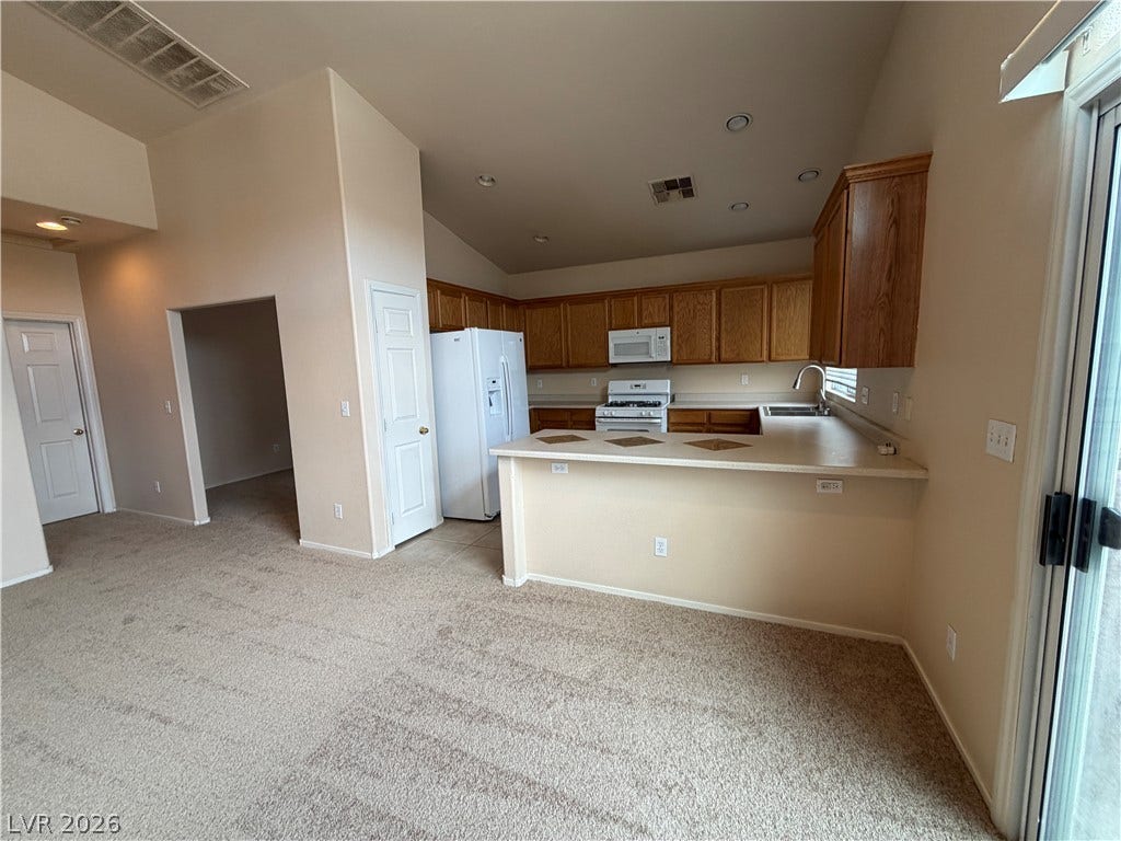 6420 W Casamar Street, North Las Vegas, NV 89086 An open floor plan seamlessly connects the carpeted living area to the kitchen.