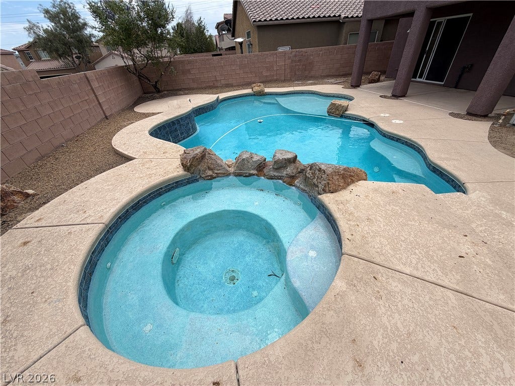 6420 W Casamar Street, North Las Vegas, NV 89086 An inviting backyard oasis features a custom swimming pool paired with an integrated hot tub.