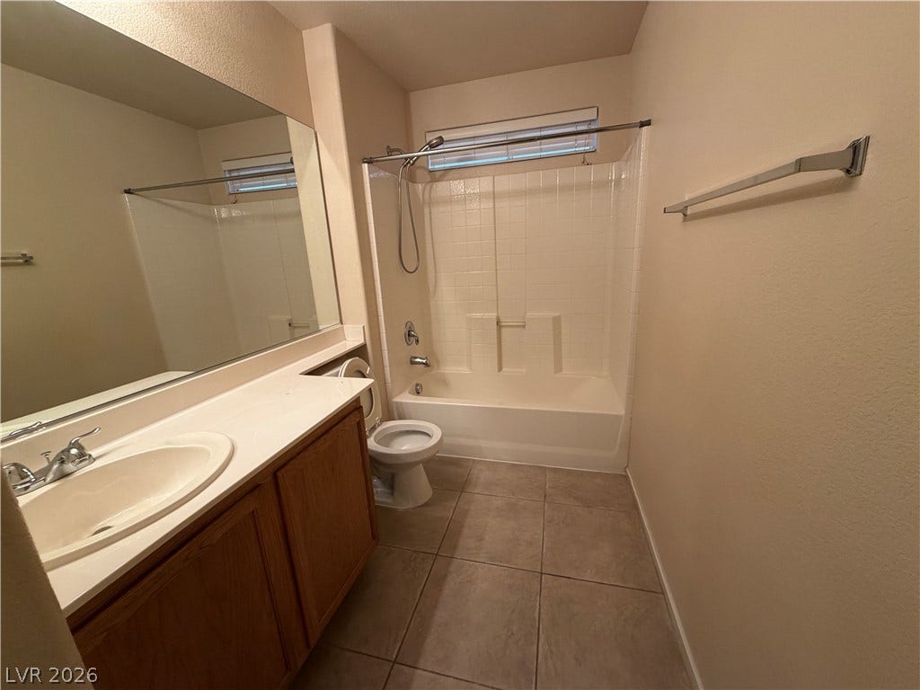 6420 W Casamar Street, North Las Vegas, NV 89086 Functional layout incorporates a tub and shower combination alongside a large vanity mirror.
