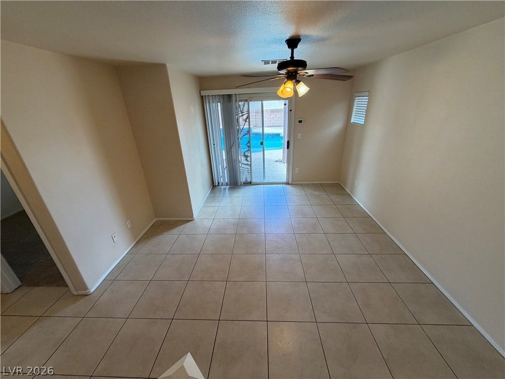 6420 W Casamar Street, North Las Vegas, NV 89086 Sliding glass doors open directly to the backyard pool area from this tiled living space.