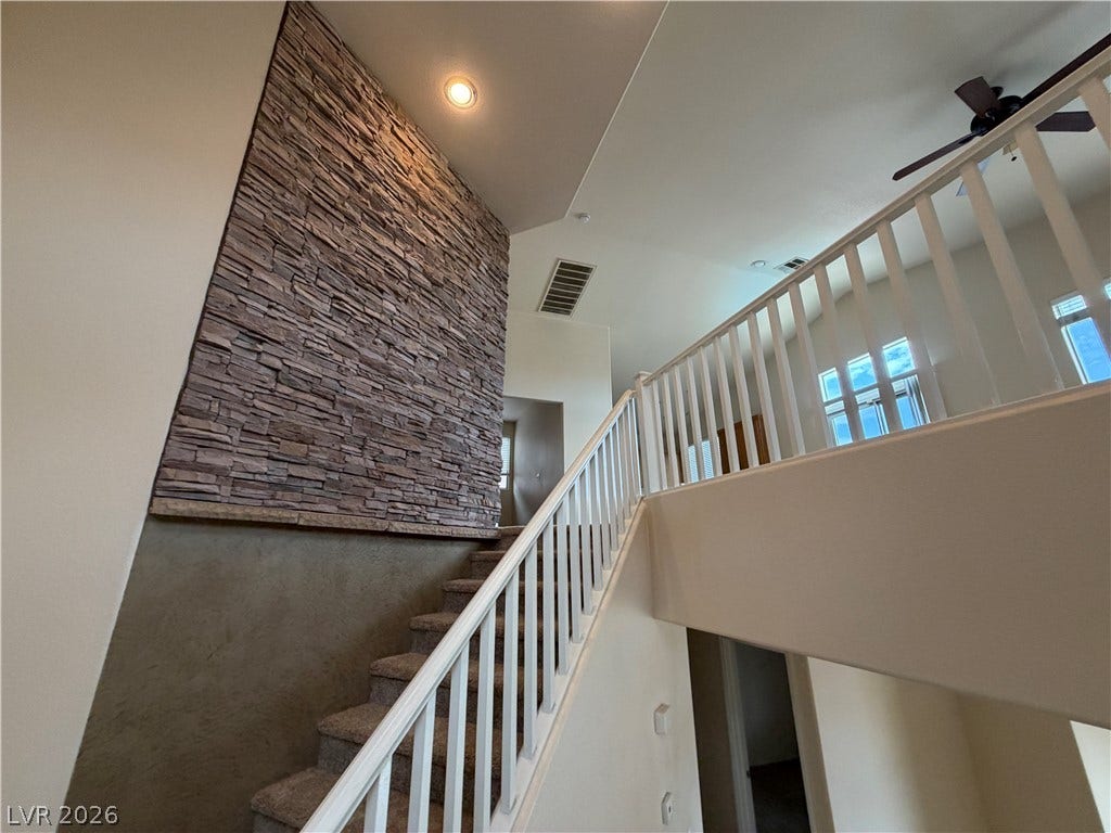 6420 W Casamar Street, North Las Vegas, NV 89086 An open staircase climbs past a textured stone wall to the second-story overlook.