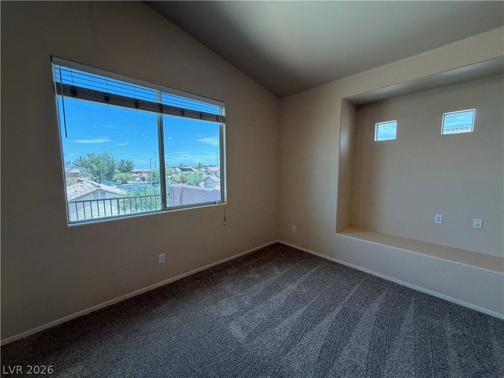 6420 W Casamar Street, North Las Vegas, NV 89086 Plentiful natural light fills this bedroom featuring a vaulted ceiling and wall recess.