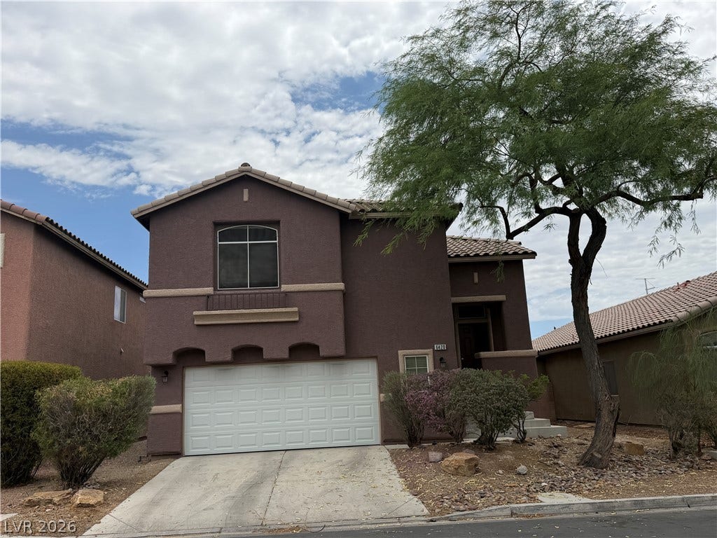 6420 W Casamar Street, North Las Vegas, NV 89086 Desert landscaping and a concrete driveway lead to a two-story home with a two-car garage.