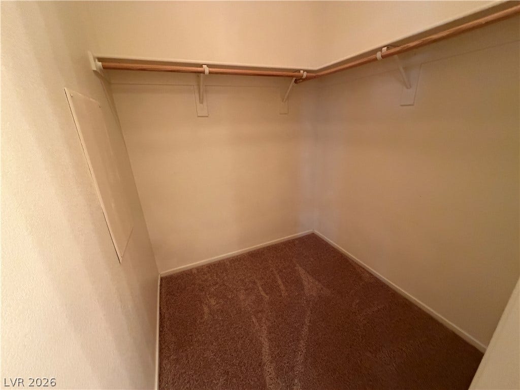 6420 W Casamar Street, North Las Vegas, NV 89086 A spacious walk-in closet includes built-in hanging rods and soft carpeting underfoot.