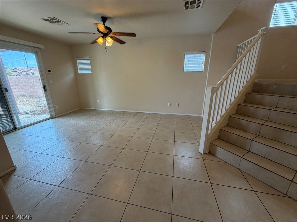 6420 W Casamar Street, North Las Vegas, NV 89086 Tiled flooring and a classic staircase define this versatile open living space.