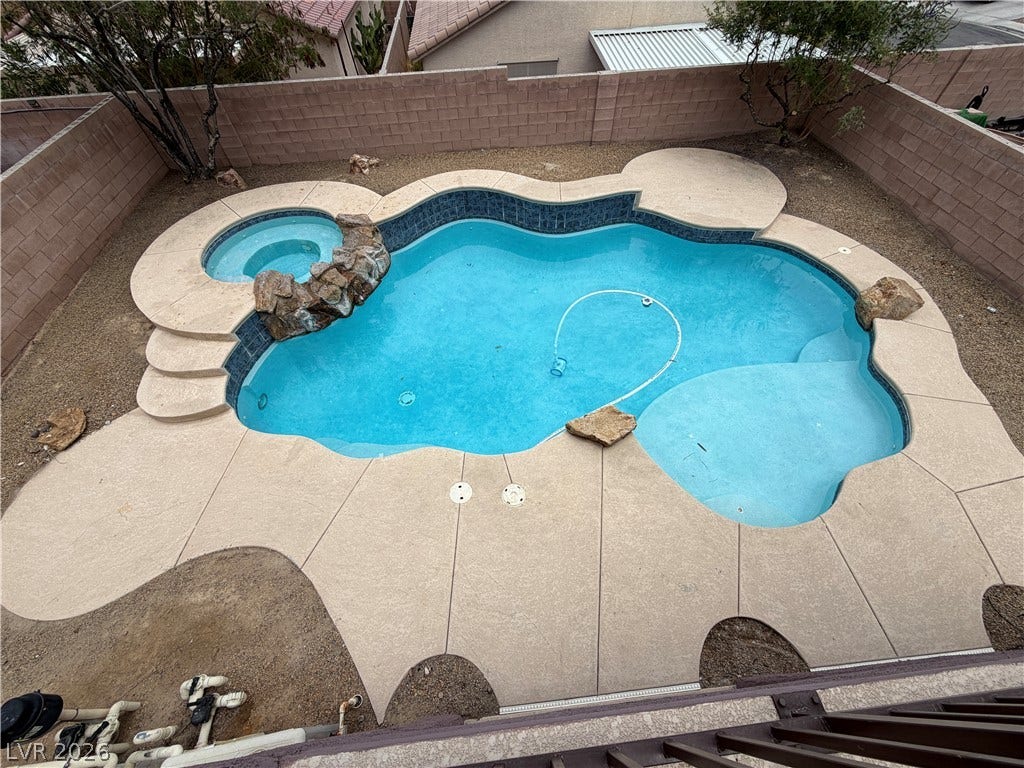 6420 W Casamar Street, North Las Vegas, NV 89086 A private backyard oasis features a freeform swimming pool and integrated spa enclosed by masonry fencing.