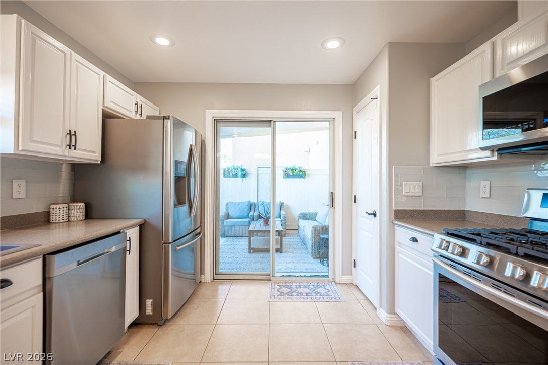 A sliding glass door opens from this tiled kitchen directly to the patio area.