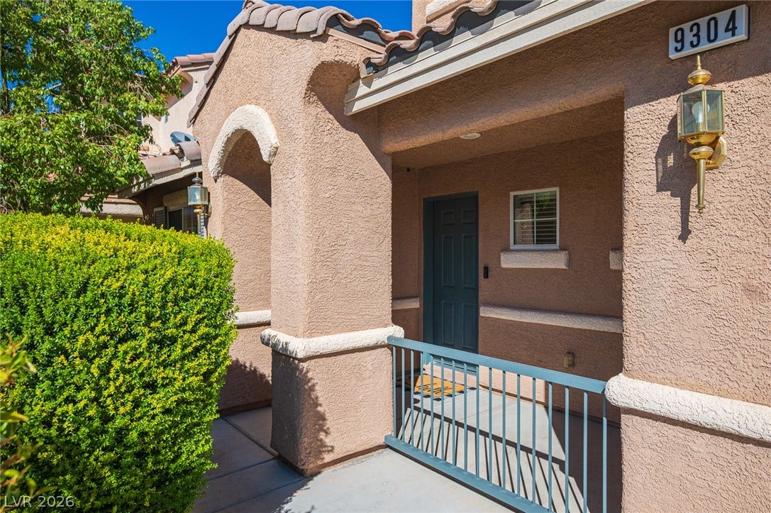 An inviting covered entryway welcomes visitors with classic Mediterranean styling and neat stucco finishes.