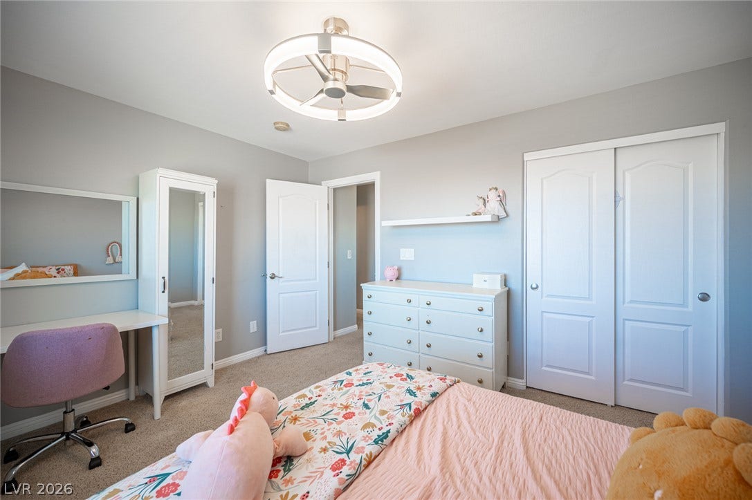 Plush carpeting and integrated storage closets define this well-proportioned secondary bedroom.