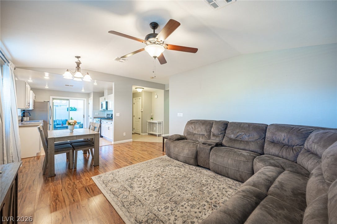 Rich wood flooring runs throughout this airy, open-concept living area.