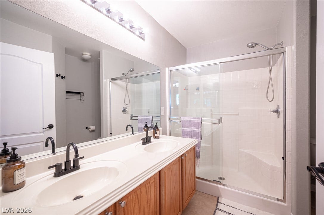 A spacious double vanity and a glass-enclosed shower highlight this functional bathroom design.