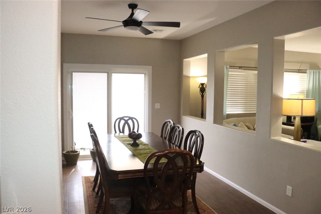 An open dining area features wood flooring and sliding glass doors leading outside.