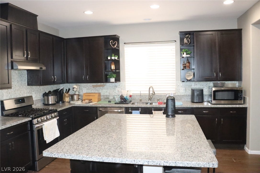 Polished granite countertops and dark wood cabinetry define this modern, functional workspace.
