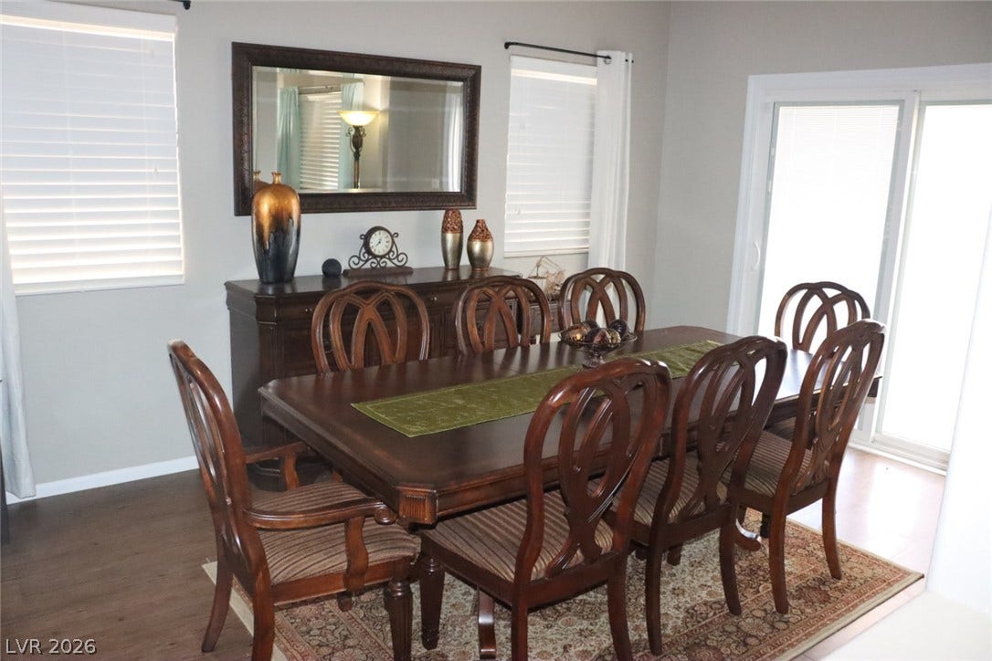 Natural light fills this elegant dining space featuring rich wood flooring and sliding glass doors.