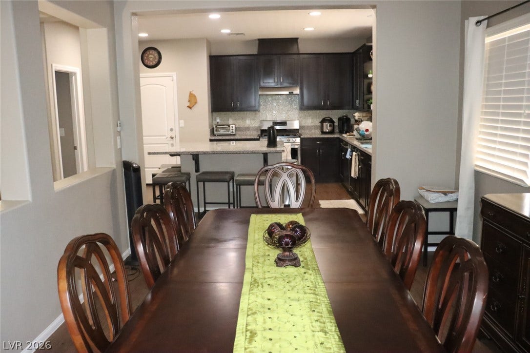 An open dining area flows seamlessly into the kitchen through a wide architectural archway.