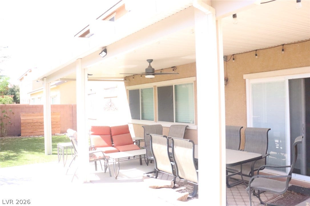 An inviting covered patio offers a sheltered retreat overlooking the green lawn.