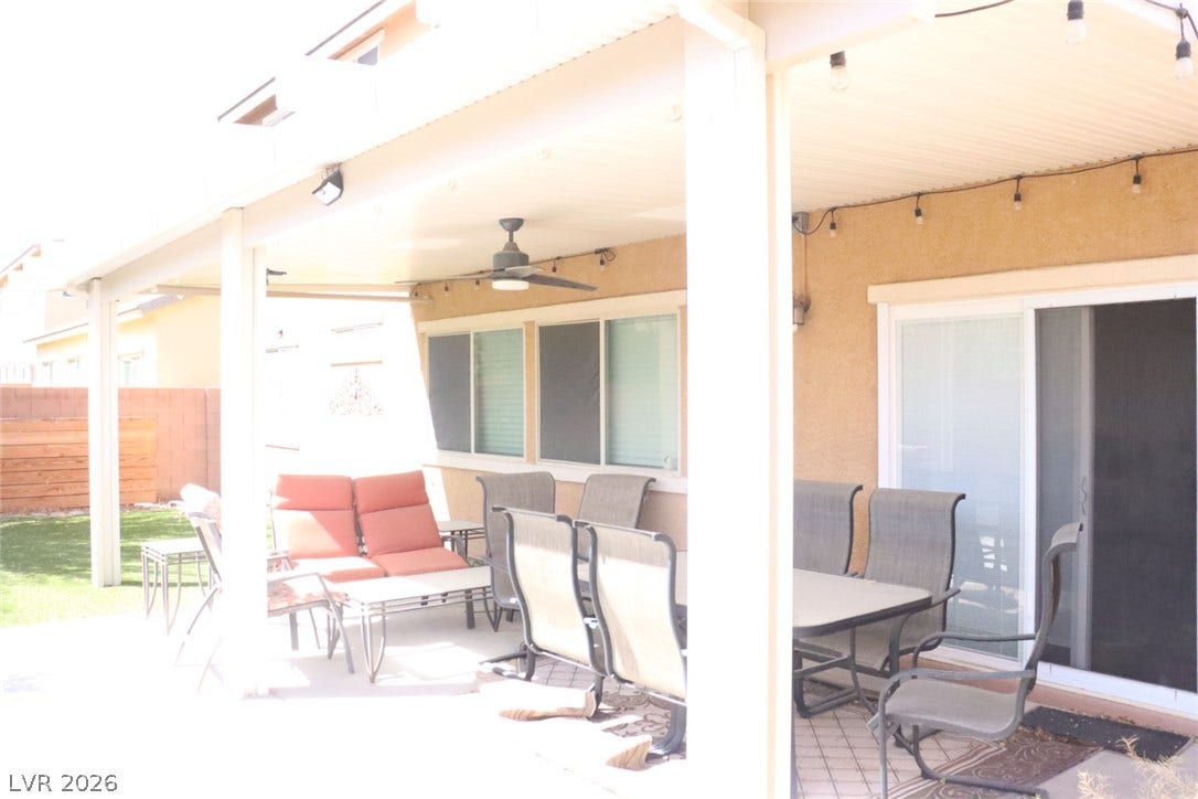 A spacious covered patio provides comfortable outdoor living space adjacent to the grassy yard.
