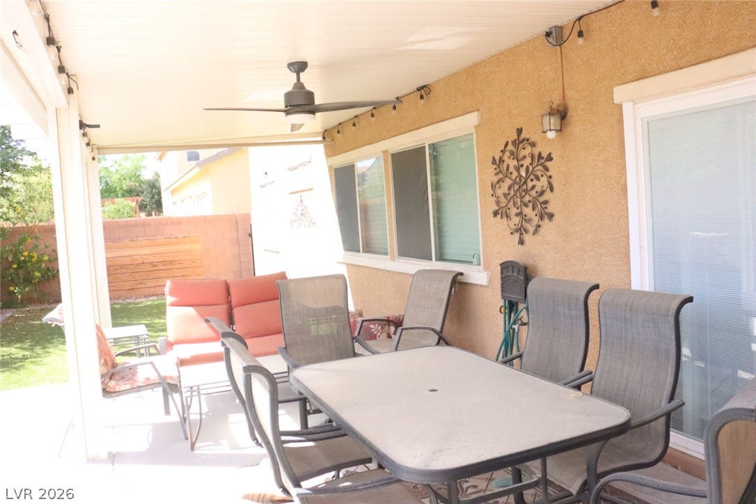 An inviting covered patio features stucco walls and concrete flooring overlooking the yard.