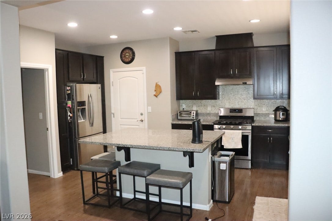 Rich dark cabinetry and a stone-topped island highlight this beautifully finished workspace.