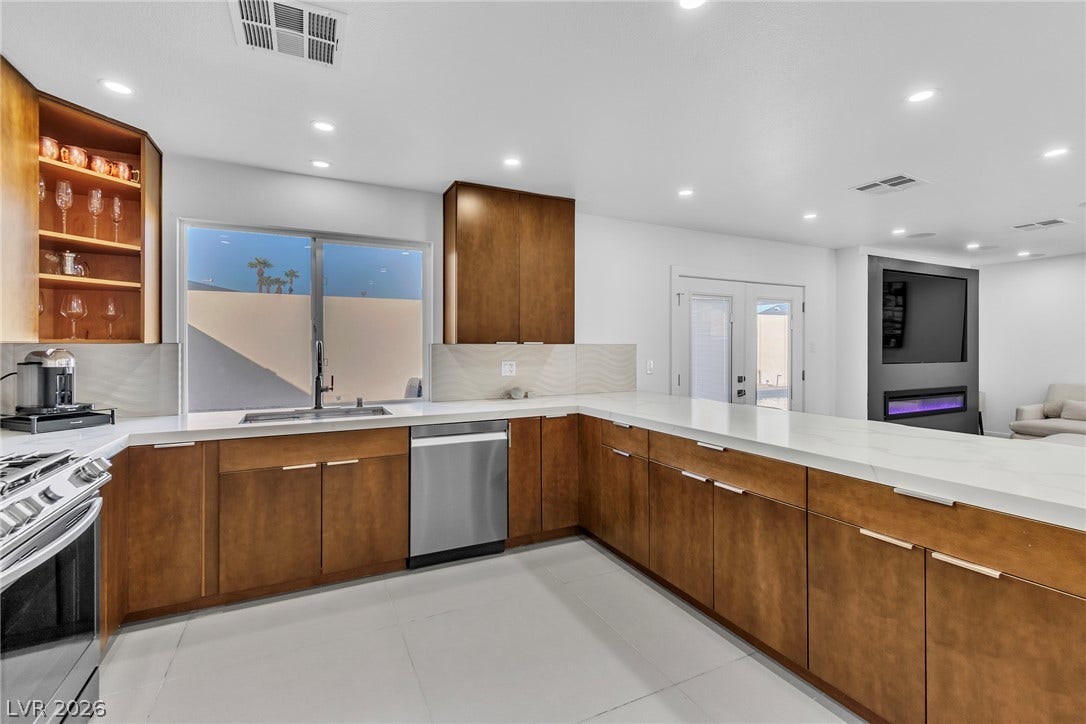 4170 Sheppard Drive, Las Vegas, NV 89121 Gleaming stone countertops and warm wood cabinetry anchor this spacious culinary space.